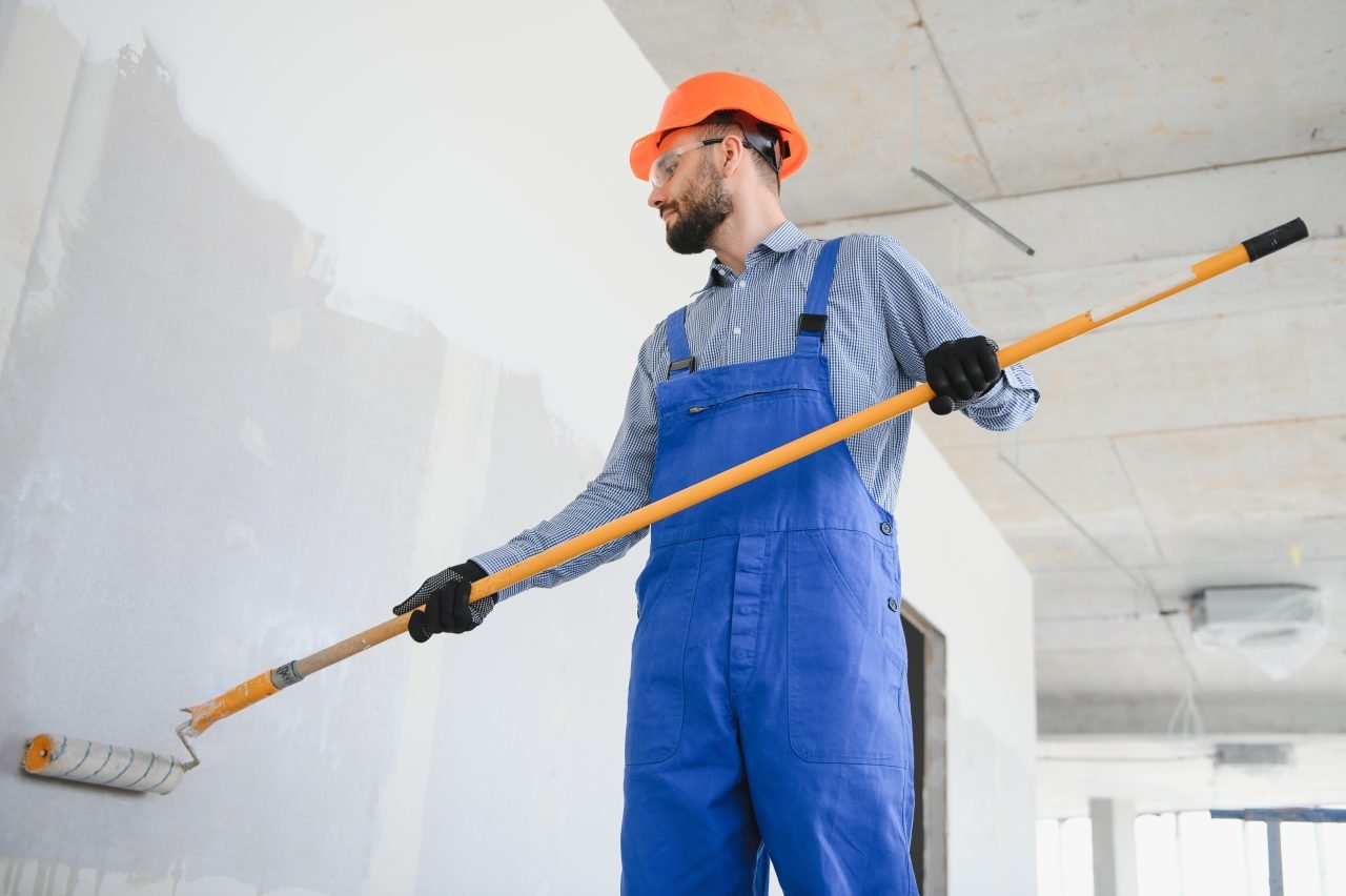 painter man painting the wall with paint roller e1